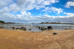 Wide sandy bay with scattered granite rocks in Tregastel Brittan, a Nature Photo by GoodGoods
