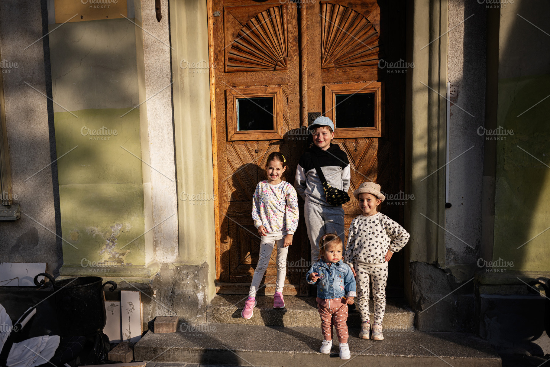 Group of cheerful children posing in front of a wooden door outdoors, a Person Photo by AS photostudio