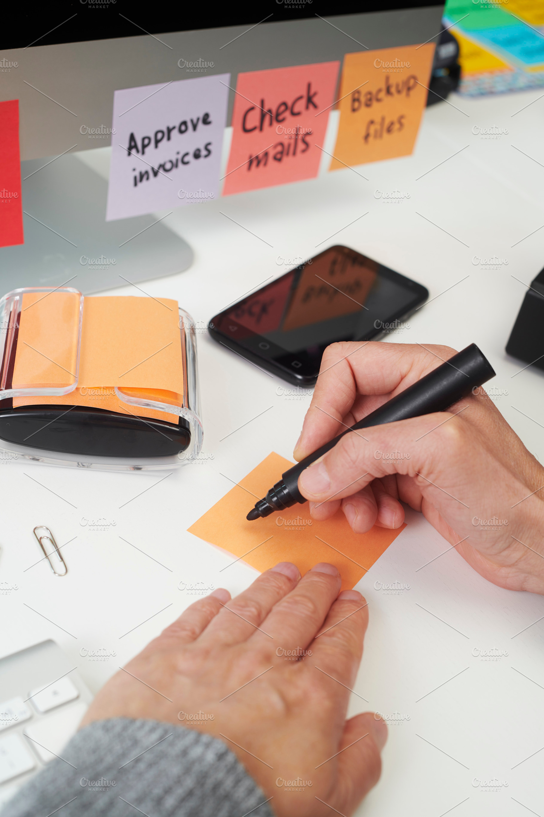 a man prepares to write a task note at a desk, a Photo by Nito