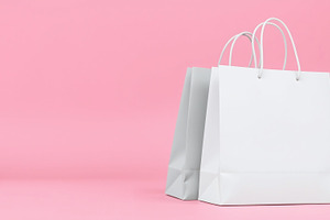 White shopping paper bags on pink, a Photo by Bunny's Little Shop