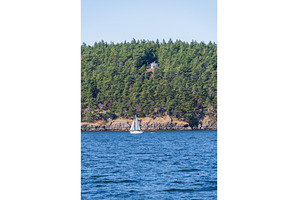 Yacht sailing between two small, a Nature Photo by Backyard Stock