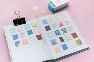 Crafting journal with decorative paper stamps and hole puncher, an Arts & Entertainment Photo by Olena Rudo