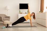 African Female Exercising Doing Side Plank Raising Arm At Home, a Photo by Prostock-Studio (Thumbnail 2 of 2)