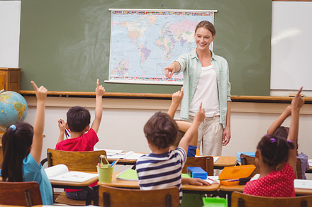 Pupils raising hand in classroom, a Photo by wavebreak
