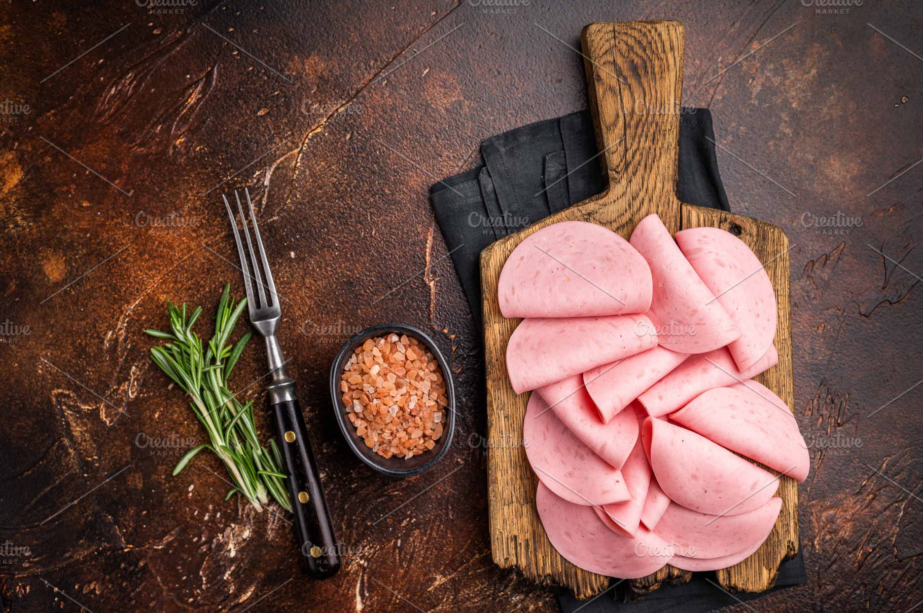 Overhead view of cold cuts (mortadella) garnished with rosemary, a Food & Drink Photo by composter-box@mail.ru