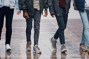 Group of five teenager walking on wet street, a Photo by DanFLCreativo