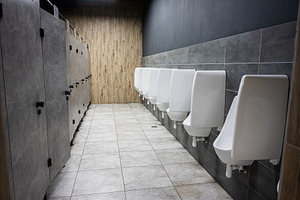 Modern restroom interior with urinals and stalls, clean tiled de, a Photo by AS photostudio