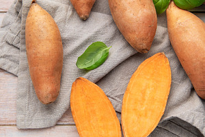 Fresh sweet potatoes and basil on wooden background, a Food & Drink Photo by Olena Rudo