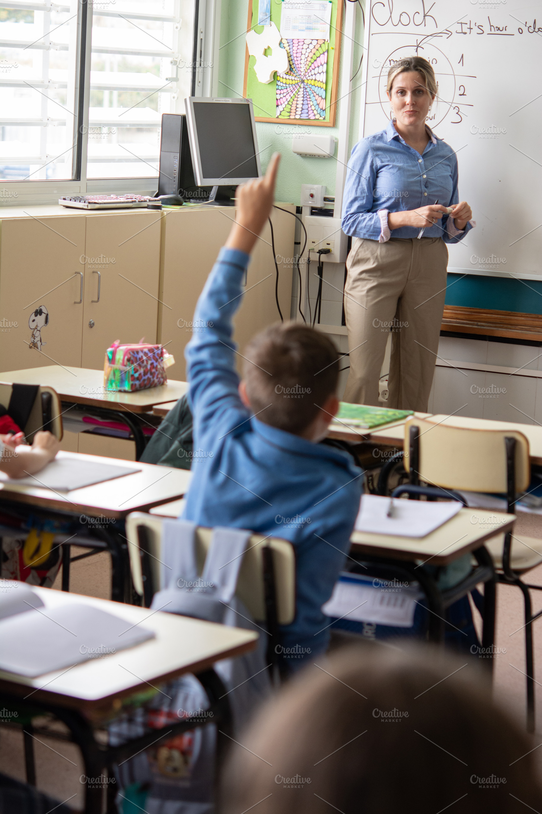 Elementary School Student Raising Hand During Classroom Lesson with Teacher, a School & Education Photo by etorres69