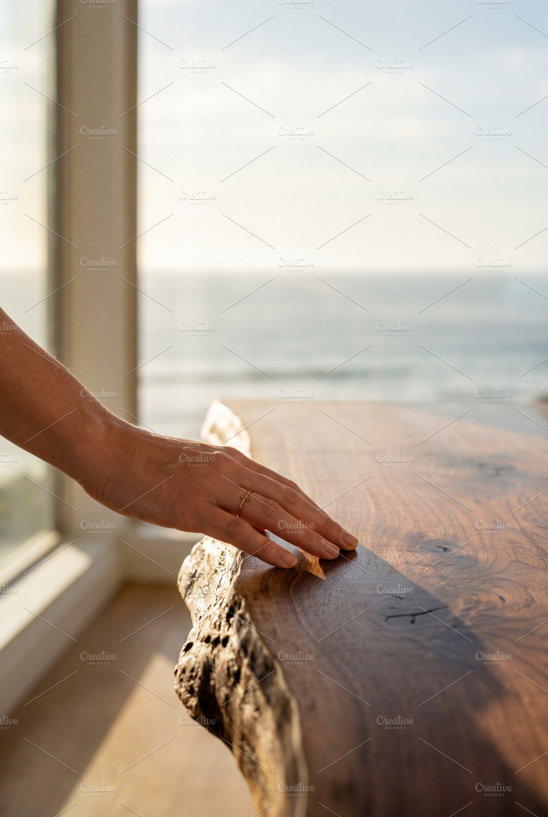 Woman's hand touching wood table, an Architecture Photo by Virgo Studio