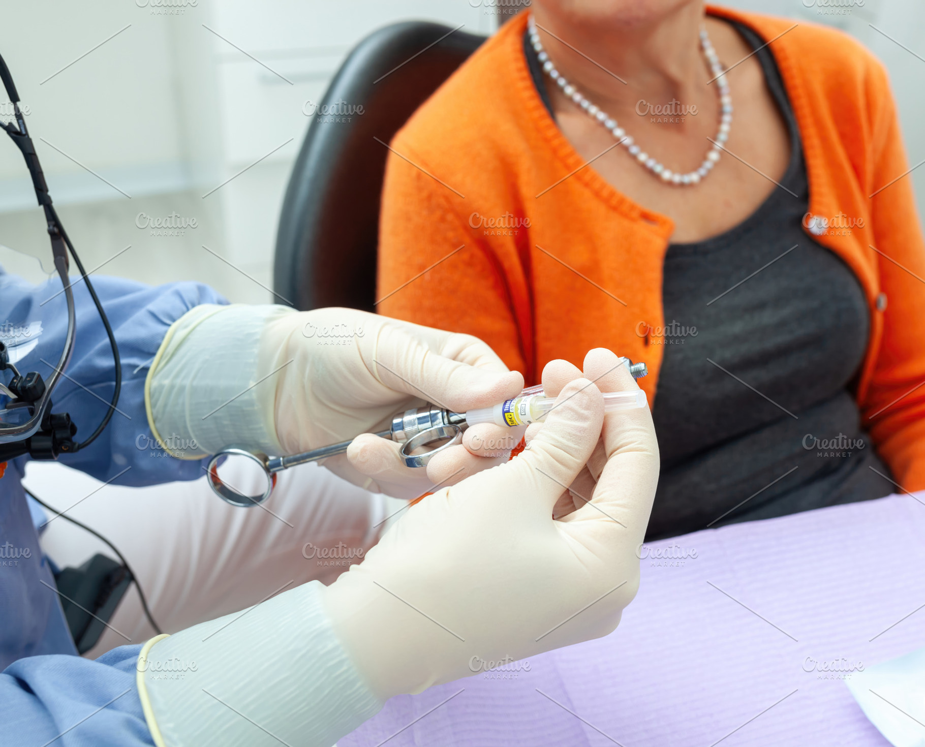 Dentist preparing anesthetic injection for senior patient, a Health & Medical Photo by Antonio Gravante Market