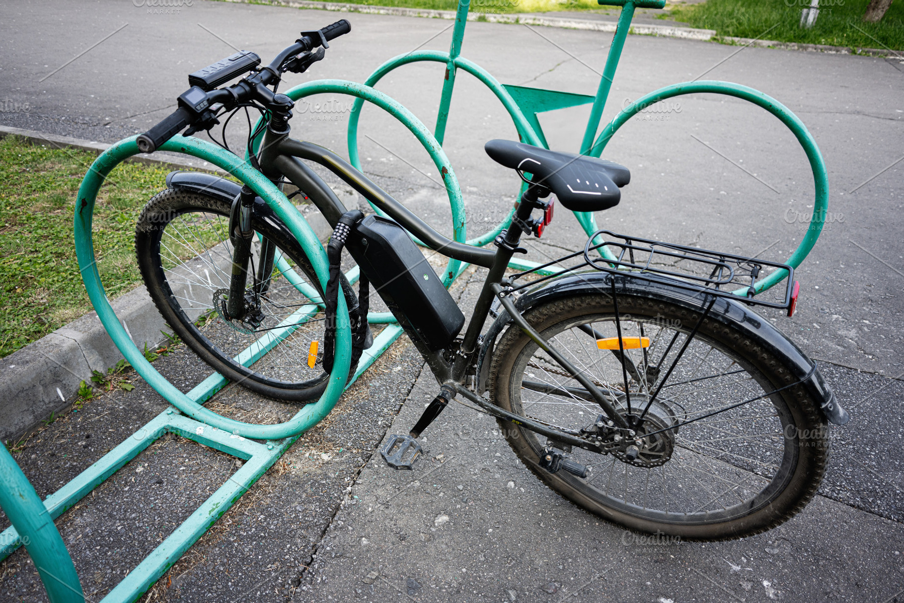 Modern electric bicycle parked in a public bike rack on an urban street, a Photo by AS photostudio