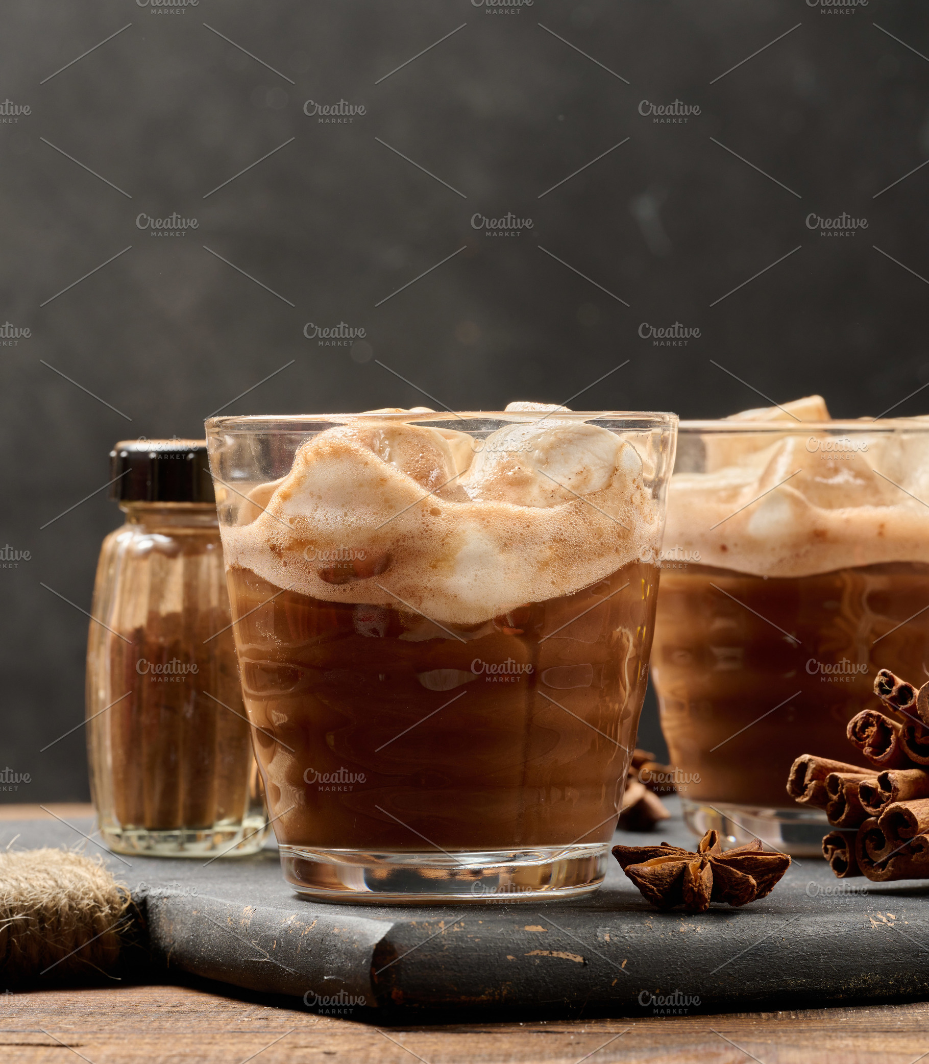 Glasses of hot chocolate with fluffy marshmallows on a wooden ta, a Food & Drink Photo by ndanko