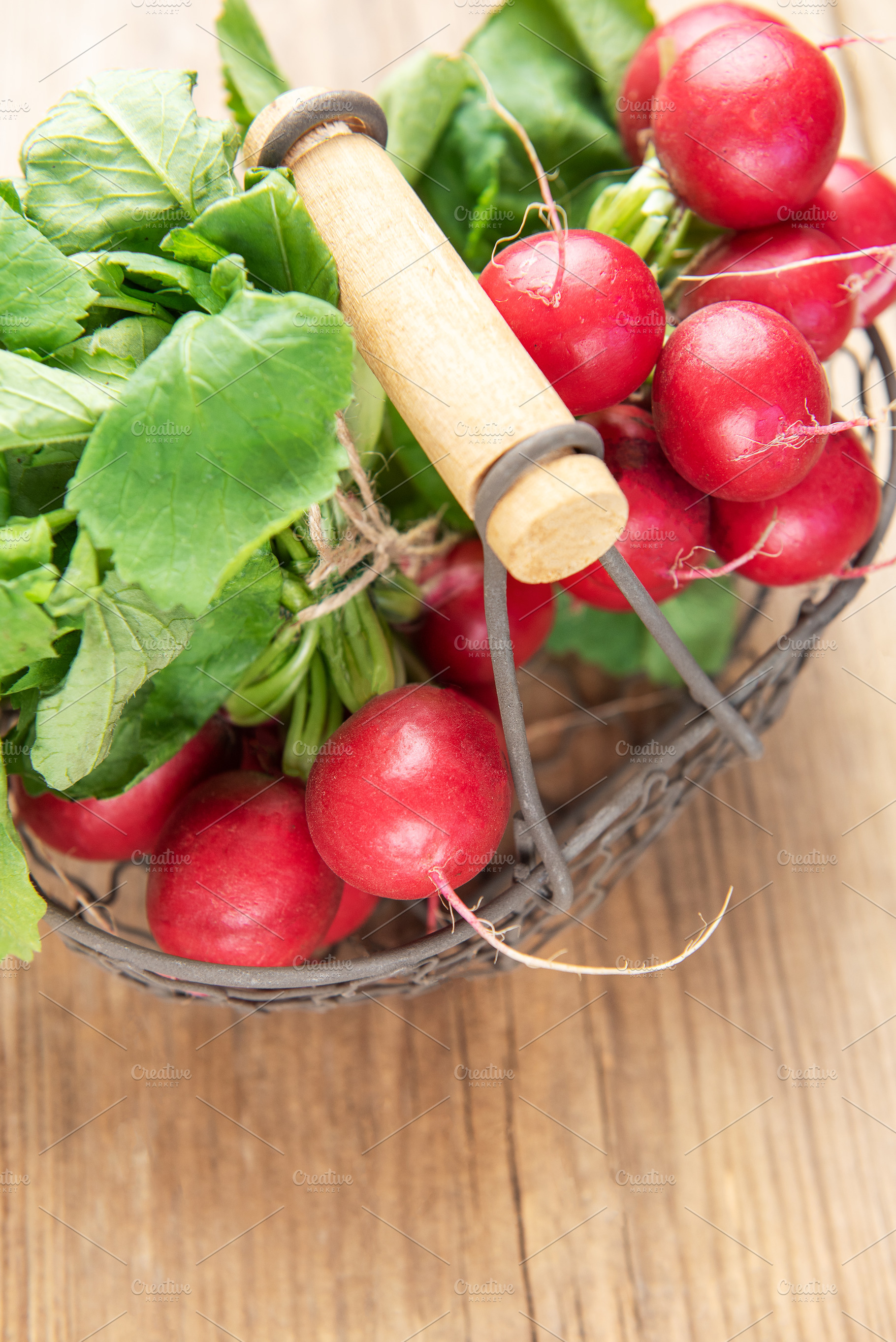 Fresh radishes with green leaves in metal basket, a Food & Drink Photo by Olena Rudo