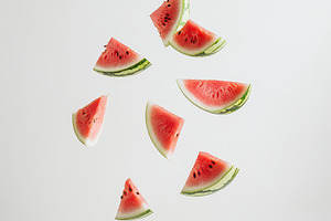 Watermelon slices falling white back, a Food & Drink Photo by Pixeness Studio