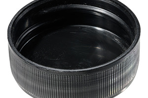 A round, black plastic bottle cap with a ribbed exterior and a s, an Industrial Photo by ndanko