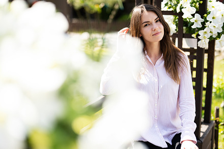 Young beautiful brunette woman in shirt sit on wooden bench with, a Person Photo by AS photostudio