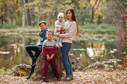 Happy family at autumn leaves park. Mother with three kids., a Person Photo by AS photostudio