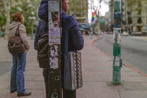 Two women standing on sidewalk waiting for public bus, a Person Photo by DanFLCreativo