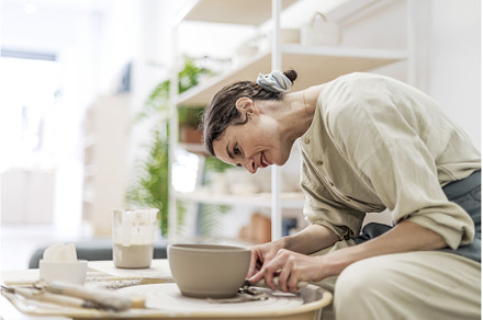 Lady siting on bench with pottery
