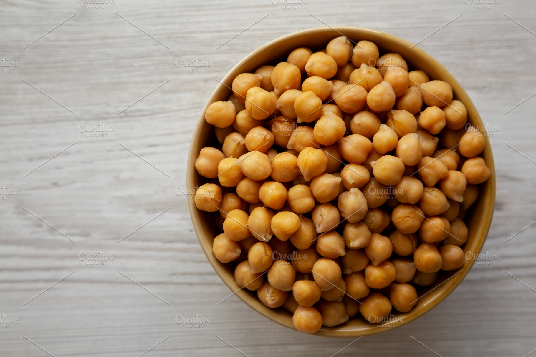 Organic Raw Canned Chickpeas in a Bowl, overhead view. Copy spac, a Food & Drink Photo by LiudmylaChuhunova