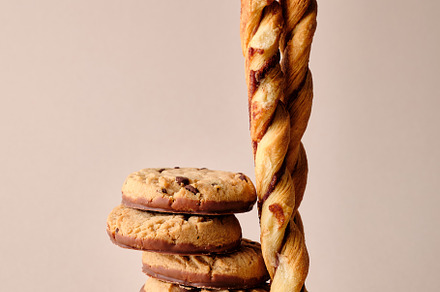 A stack of chocolate-covered biscuits and cookie sticks on beige