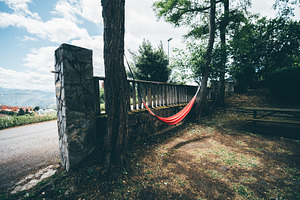 Red hammock between trees outdoors, a Sports & Recreation Photo by SkyNext