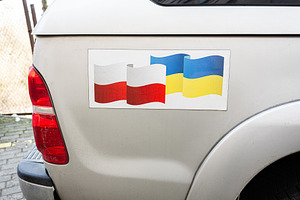Truck displaying Polish and Ukrainian flags symbolizing connection and friendsh, a Photo by AS photostudio