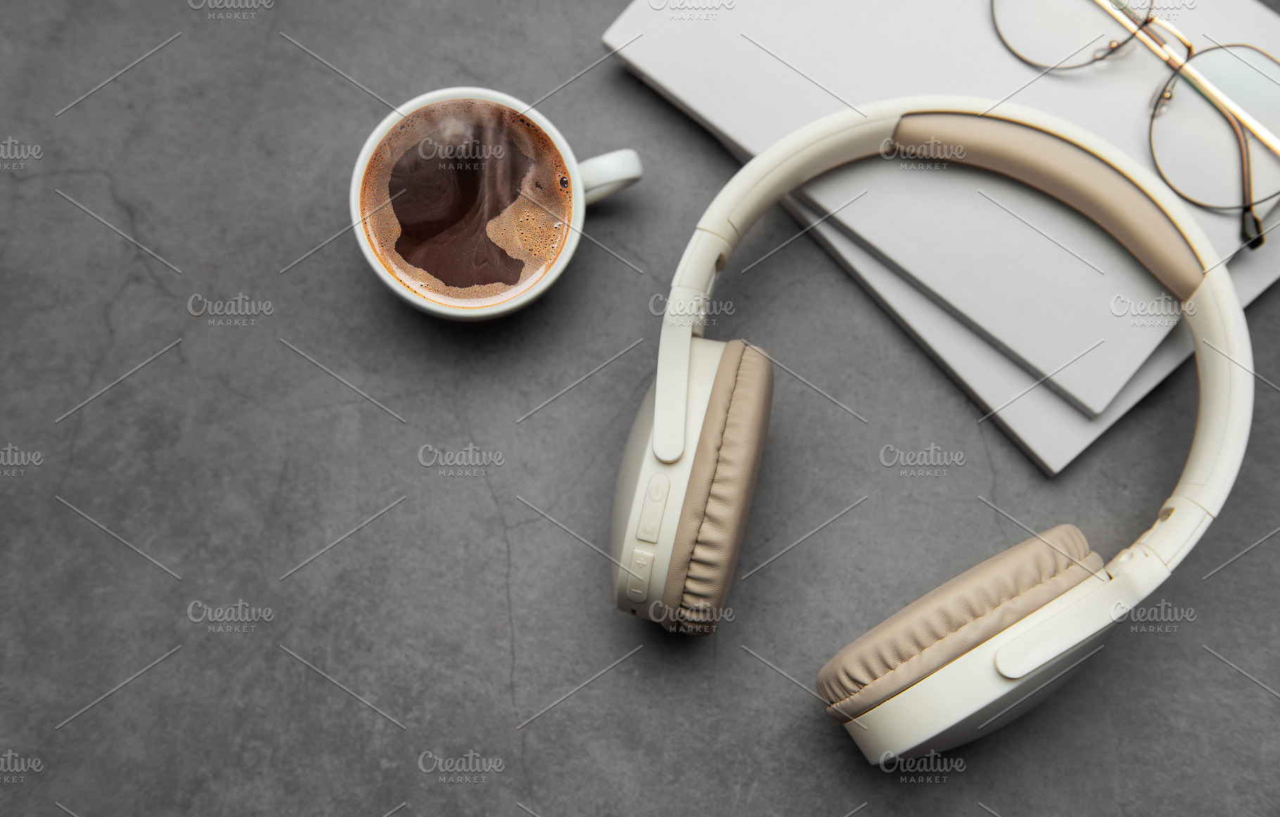 Wireless headphones, hot coffee and notebooks resting on gray ta, a Business Photo by Olena Rudo