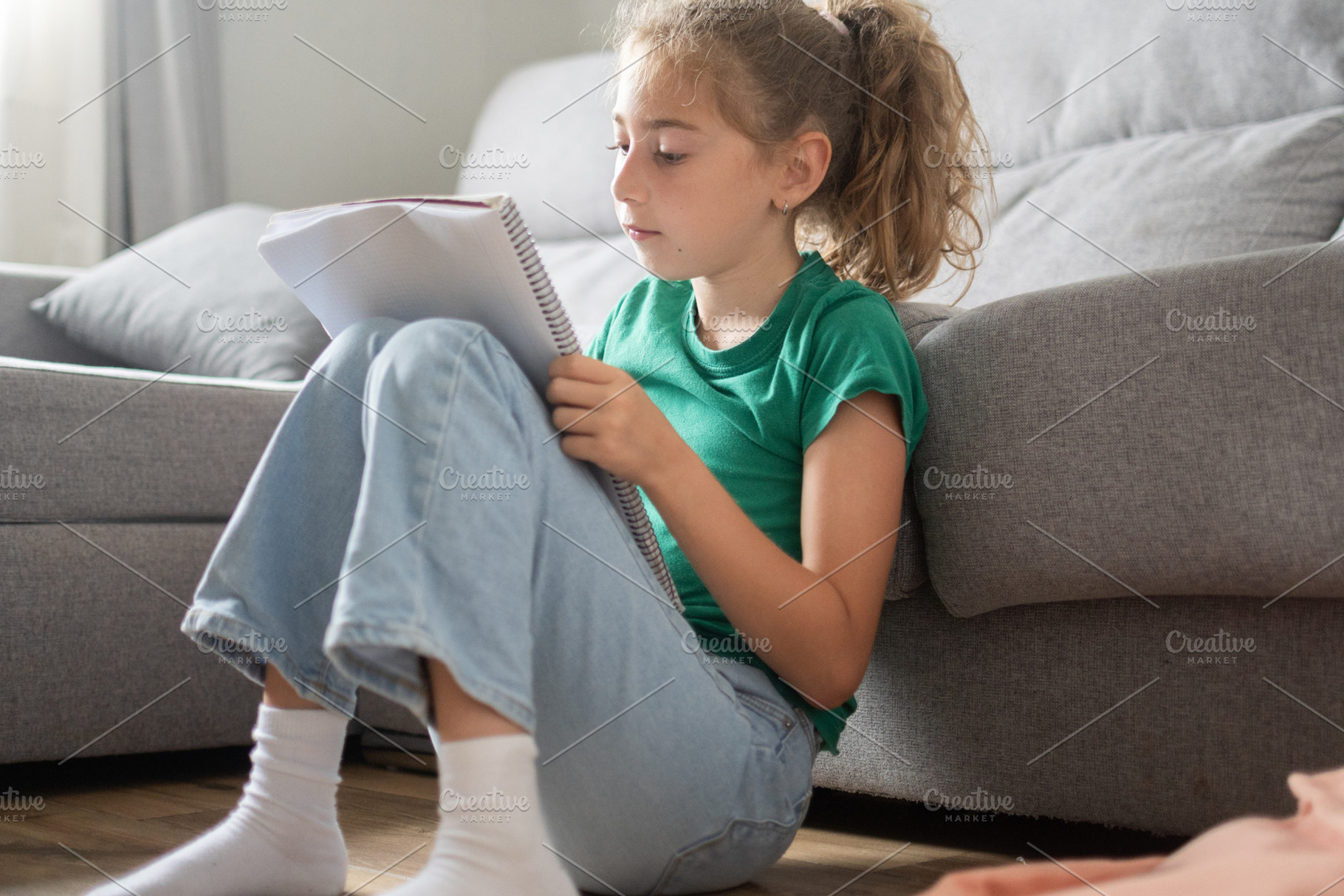 Schoolgirl Sitting on Floor at Home Reading and Writing in Notebook, a Person Photo by etorres69