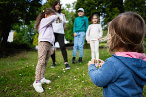 Children playing outdoors in a grassy park area during a sunny day, a Photo by AS photostudio
