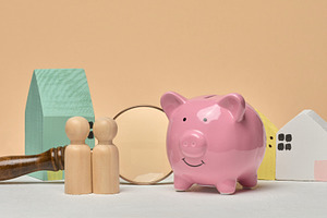 Pink piggy bank, wooden houses, wooden human figures and magnify, a Business Photo by ndanko