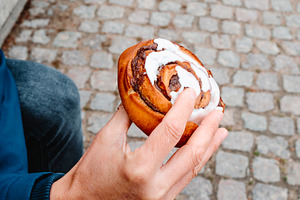a man holds a traditional kanelsnegl in Copenhagen, a Photo by Nito