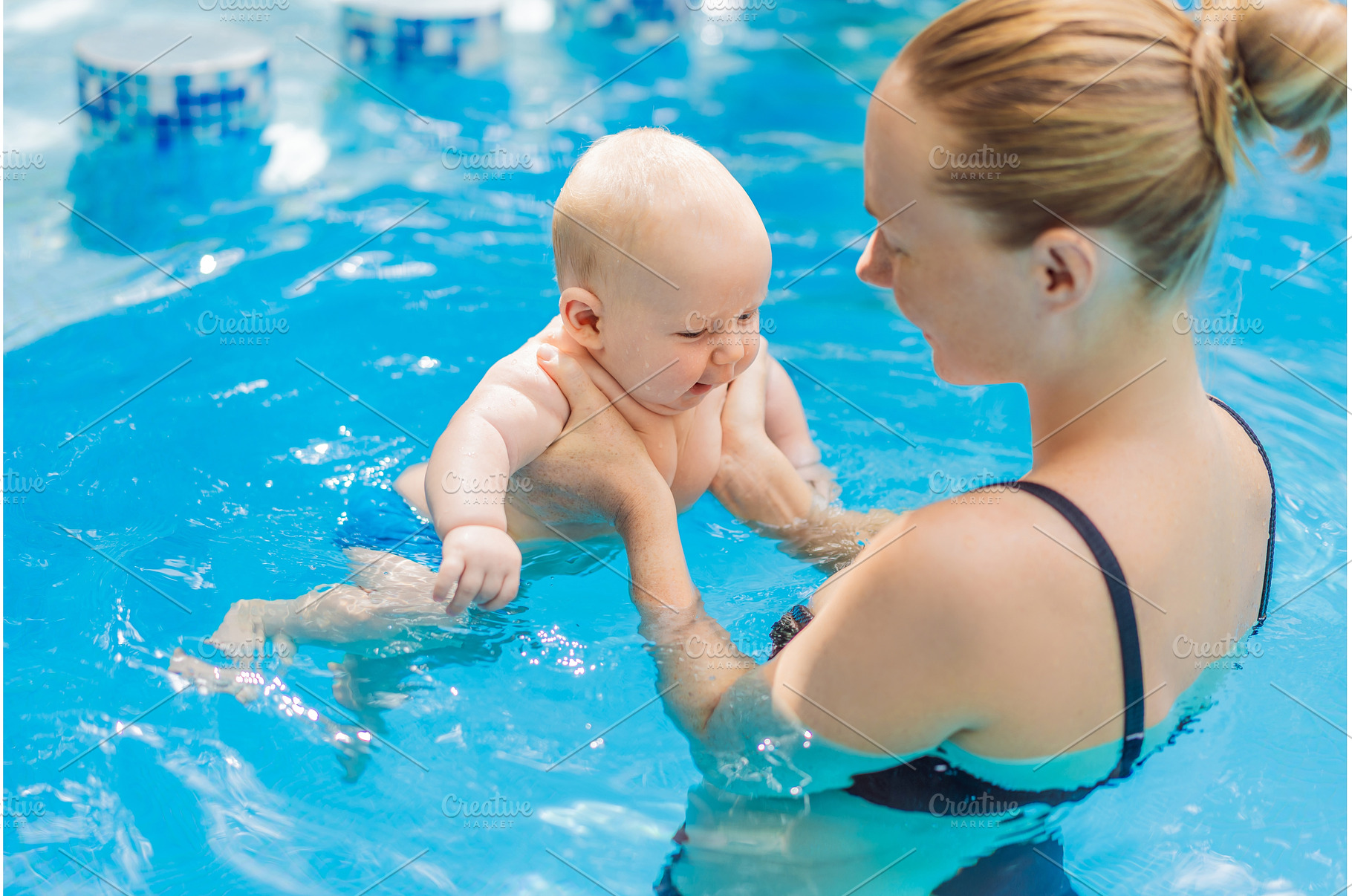 Mother bathing her baby in a, a Sports & Recreation Photo by Elizaveta Galitskaya