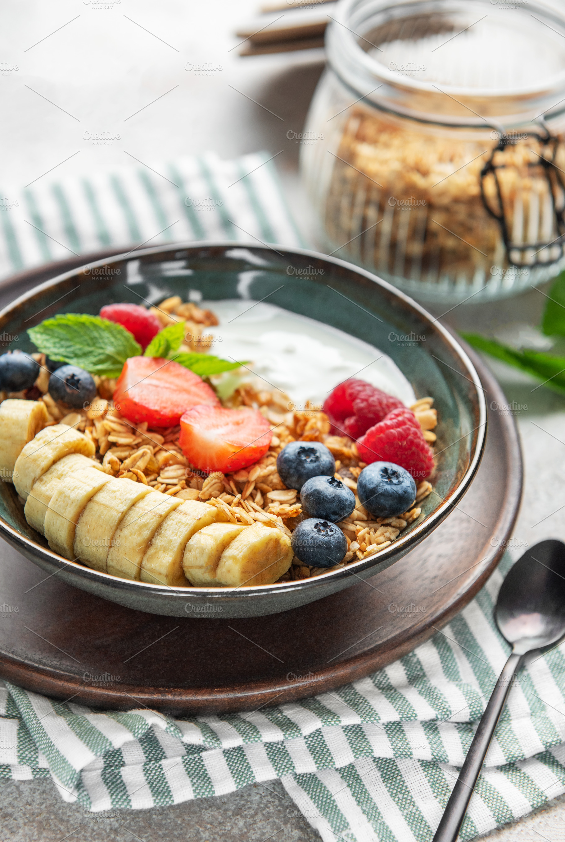 Healthy breakfast bowl with yogurt, granola, banana, and berries, a Food & Drink Photo by Olena Rudo