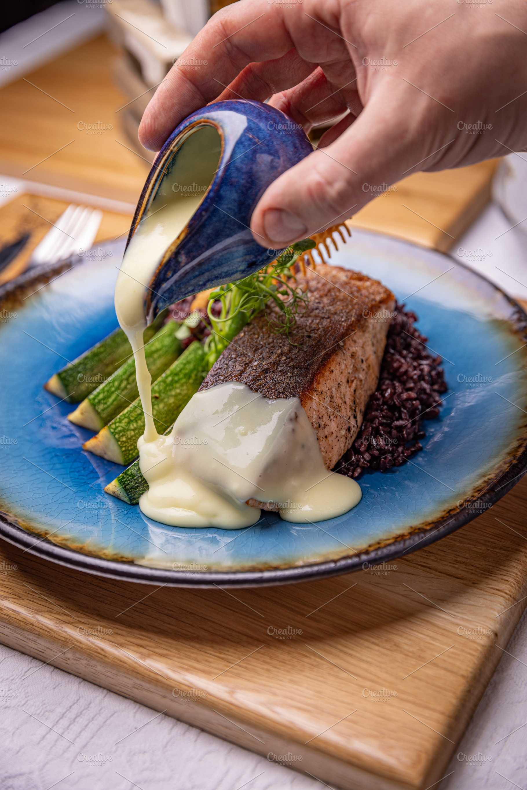 Chef pouring sauce on salmon steak, a Photo by Grafvision photography