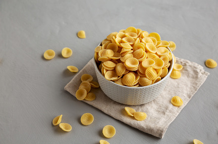 Dry, Uncooked Orecchiette Pasta in a Bowl, side view., a Food & Drink Photo by LiudmylaChuhunova