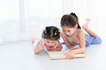 Happy two sister drawing in sketch book together at home or nurs, a Person Photo by Ministocker