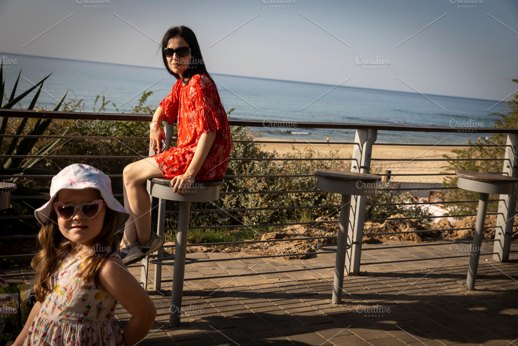 Mother and daughter on a sunny day near the sea, mother sitting, a Person Photo by Imaginarium