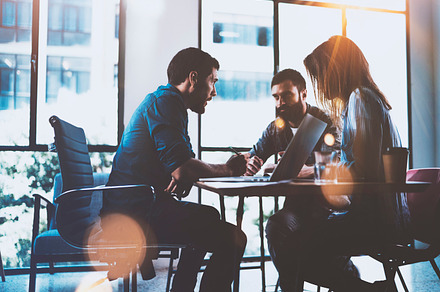 Teamwork brainstorming process.Young man working together with partners in modern office loft.Business startup concept.Blurred background.Flares.