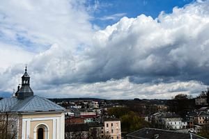 Elevated view of a serene townscape under a bright and expansive cloudy sky. Bu, a Photo by AS photostudio