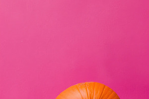 Top view orange pumpkin on pink Halloween background, a Food & Drink Photo by José Manuel Gelpi