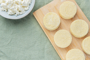 Preparing syrniki cottage cheese pancakes on cutting board, a Food & Drink Photo by Olena Rudo