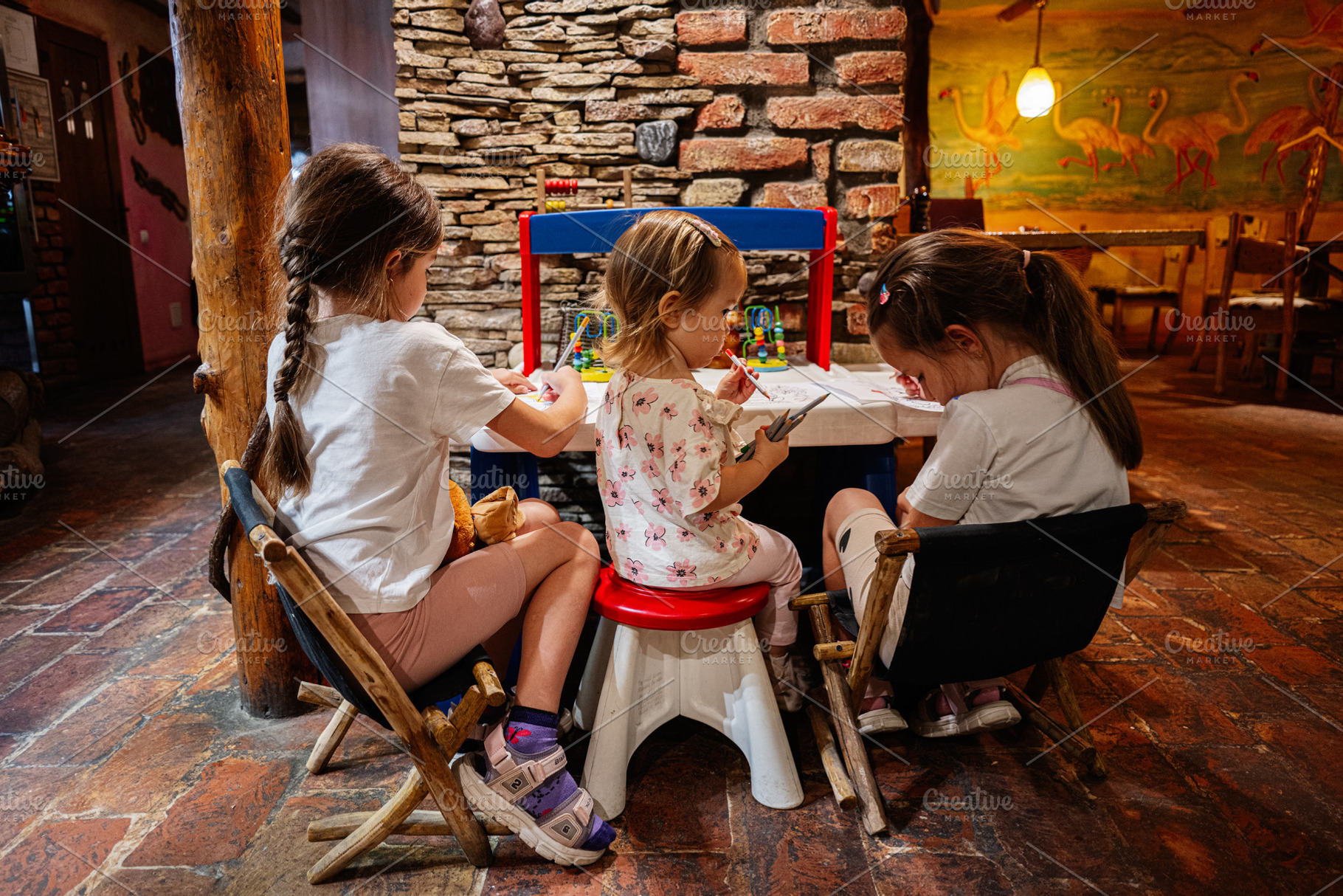 Young children engaging in creative activities around a small table in a colorf, a Photo by AS photostudio