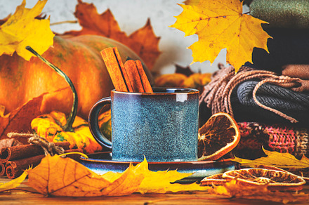 Autumn drink in blue cup on fall background with pumpkins, orang
