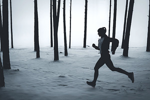 Female jogging in winter forest featuring winter, jog, and run