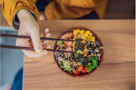 Woman eating Raw Organic Poke Bowl, a Food & Drink Photo by Elizaveta Galitskaya