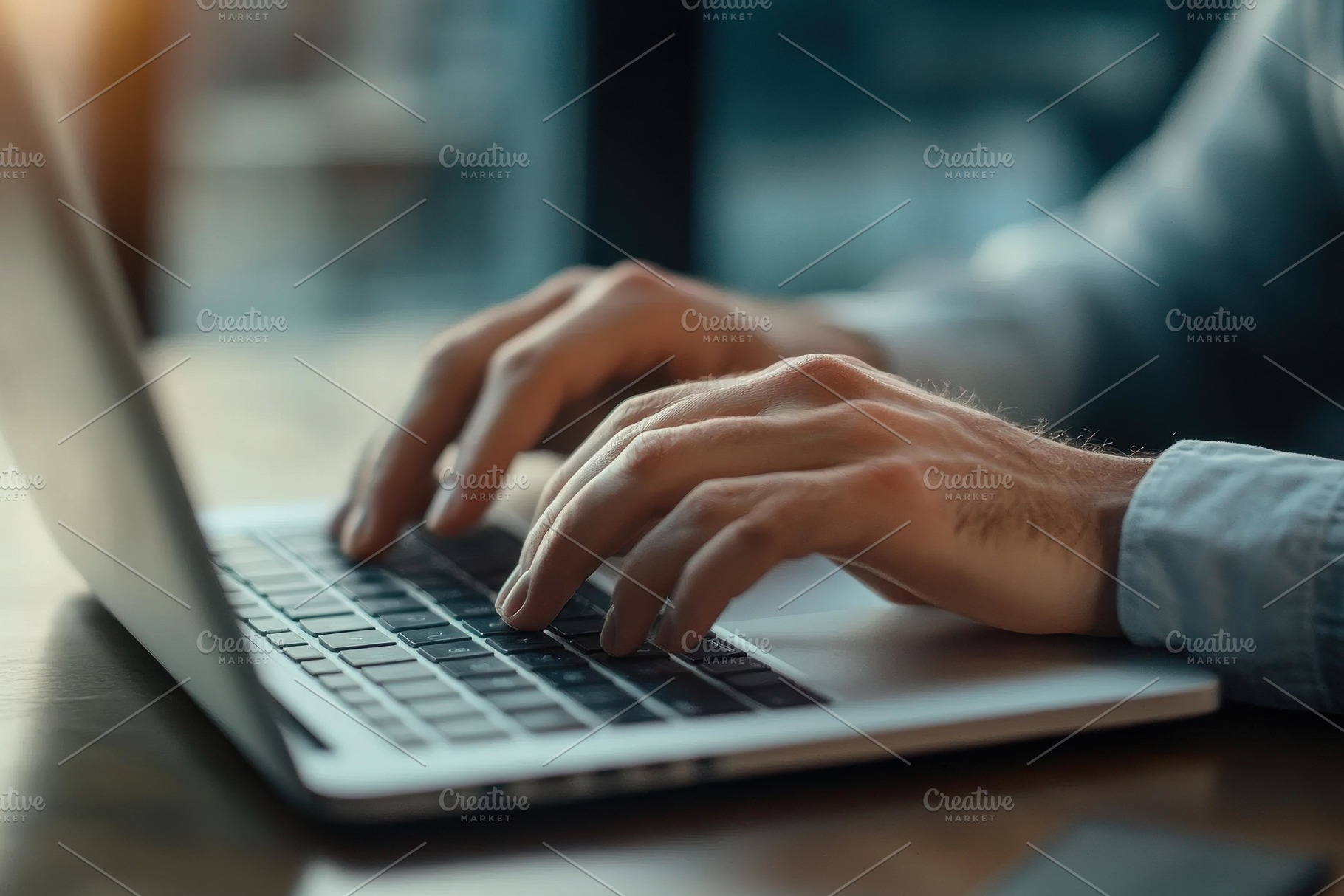 Hands typing on a laptop keyboard in, a Photo by Tanuart