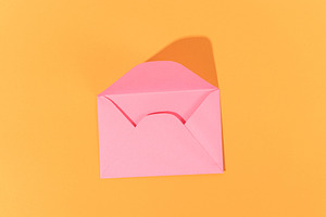 Blank pink open envelope over orange background