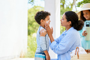 Mother applying sunscreen on child o, a Photo by Dvoevnore photos